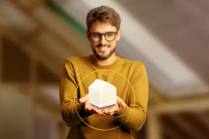 Čovjek drži mineralnu vunu u obliku kućice u ruci