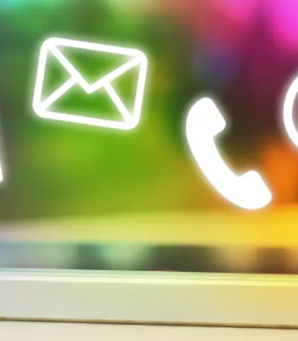 Prst pritišće mobitel na ravnoj površini, iznad mobitela ikone za kontakt